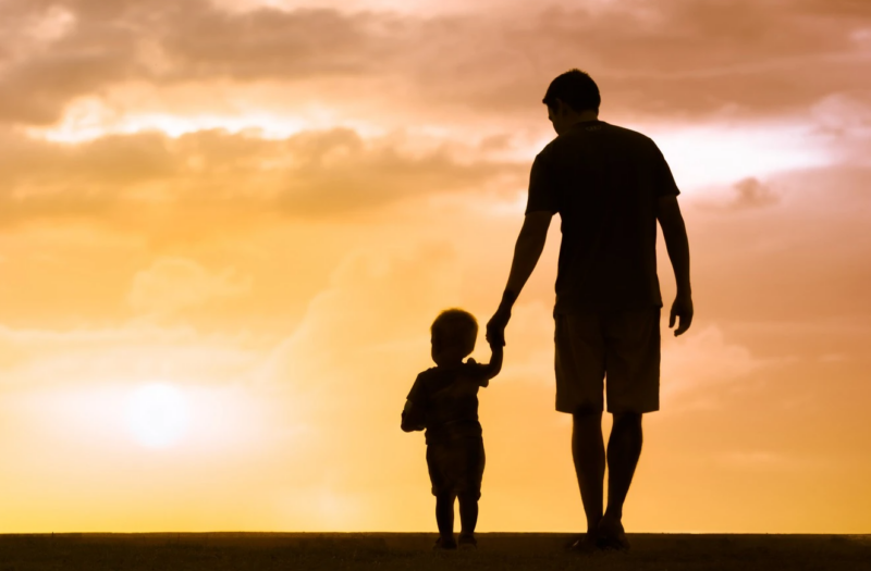 Father walking with a child towards a sunset. Depiction of raising a child with Autism