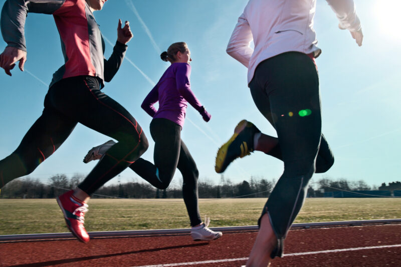 Three runners running on a track. A depiction of a regular exercise