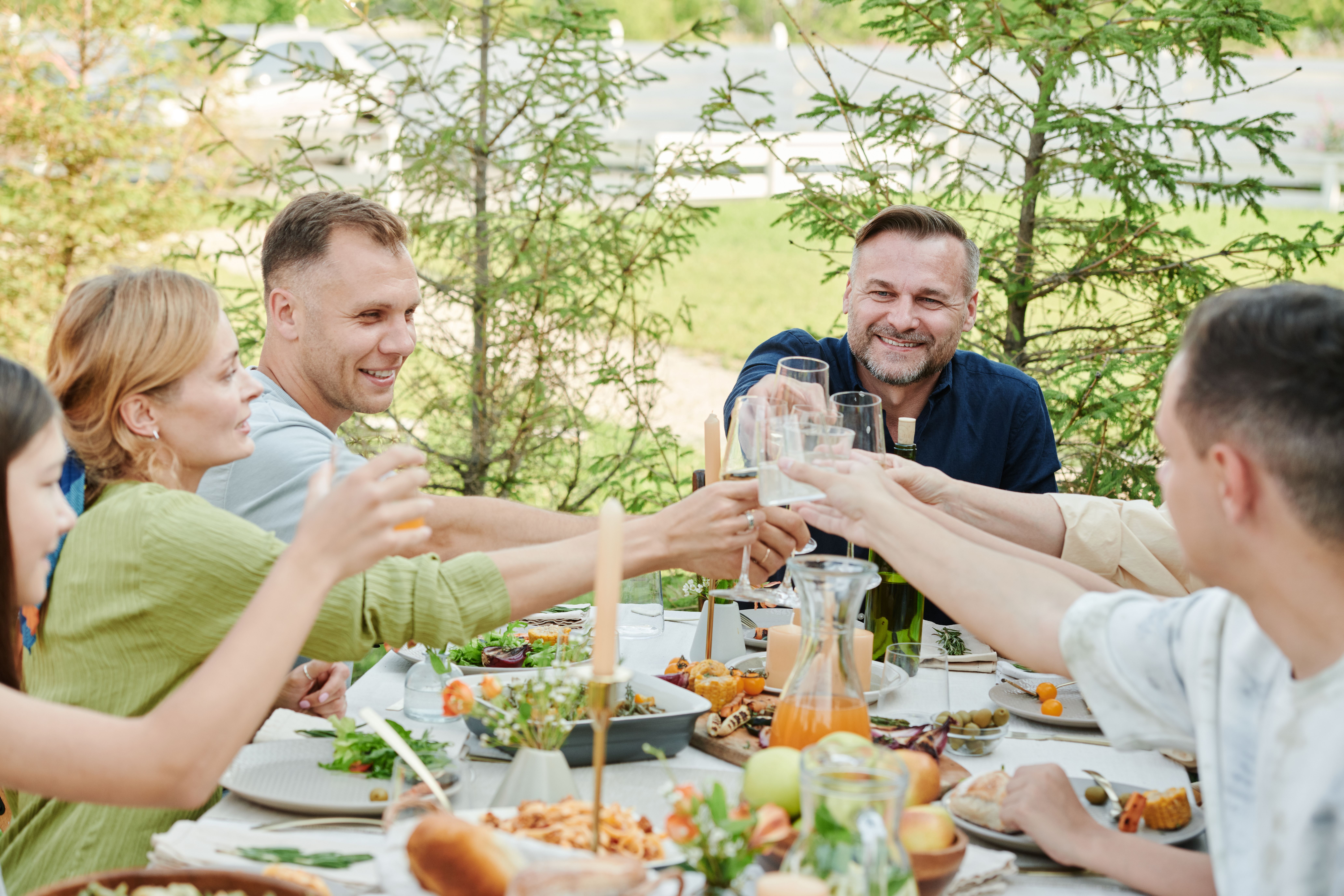 Friends enjoying an outdoor dinner together and raising a toast