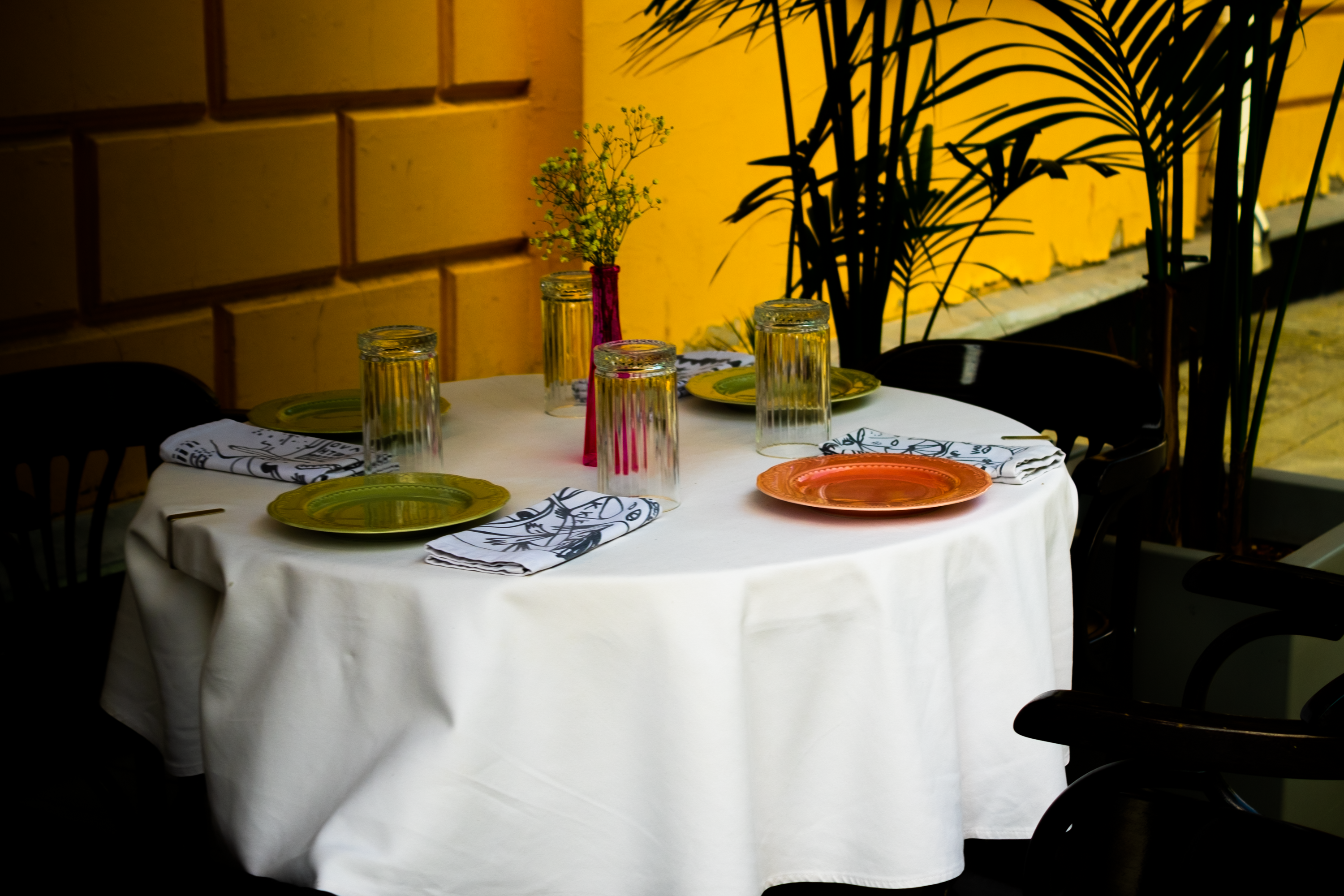 Colorful outdoor dining table set with plates and glasses